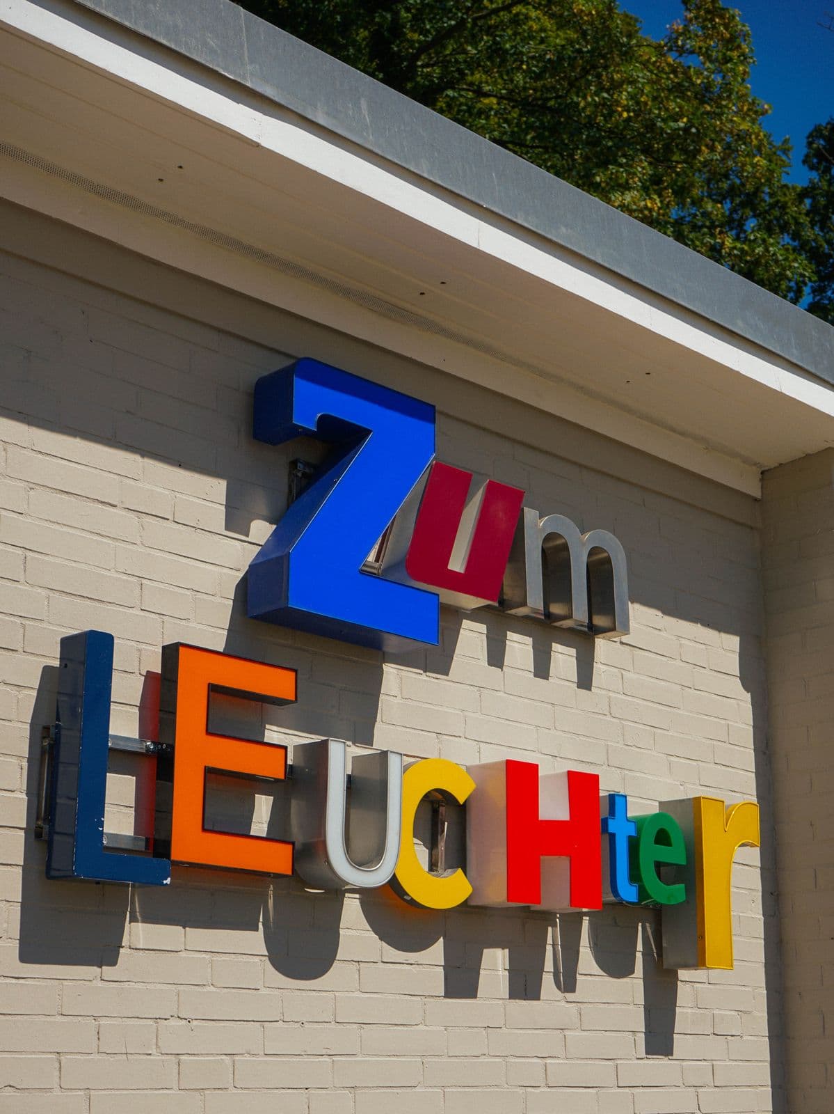 Die bunten Leuchtbuchstaben Zum Leuchter an der Kioskwand