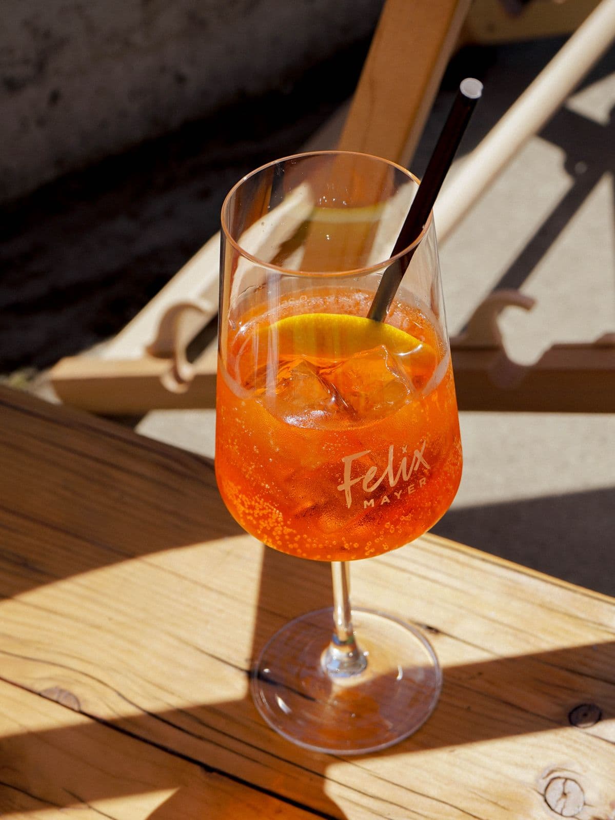 Aperol Spritz auf dem Holztisch vor einem Liegestuhl