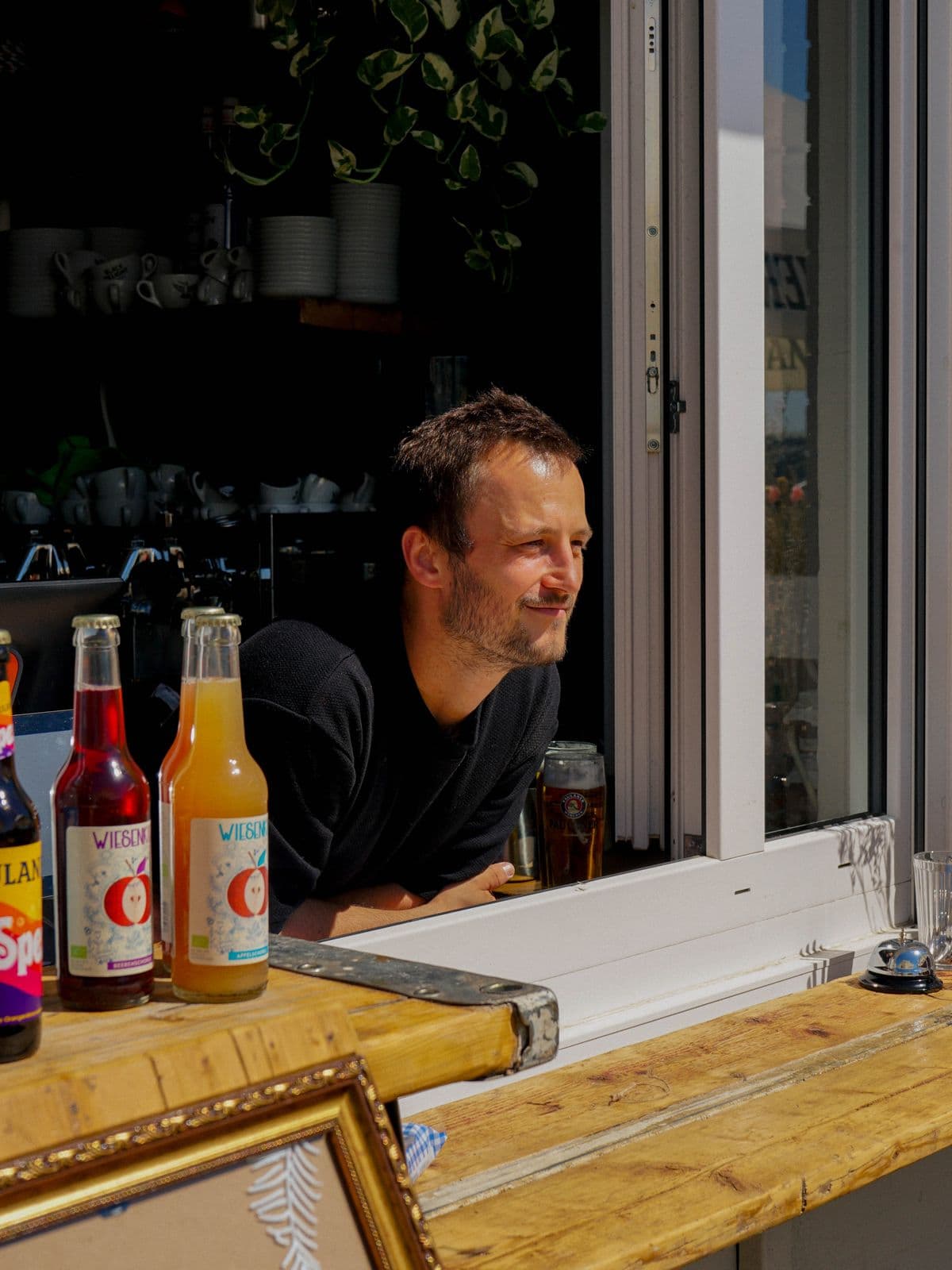 Blick ins Kioskfenster mit Schorleflaschen und frisch gezapftem Bier
